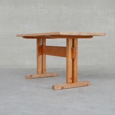 a wooden table sitting on top of a cement floor