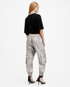 Cargo pants are so 90s, and we love it. Add a pair to your rotation - these are the Freda. Crafted from a metallic coated fabric and shaped to a regular silhouette with a tapered, cuffed leg. Pocket detailing on the legs completes the laidback aesthetic.  These pants are designed to a regular fit High-rise Zip closure Two front pockets Two side pockets Elasticated cuffs Tapered slim leg Allsaints Casual Bottoms For Fall, Allsaints Casual Fall Bottoms, Allsaints Casual Spring Pants, Metallic Bottoms With Pockets For Fall, Casual Metallic Bottoms With Pockets, Casual Metallic Pants For Night Out, Casual Metallic Pants For Fall, Metallic Casual Pants For Fall, Casual Metallic Bottoms For Fall