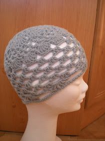 a white mannequin head wearing a gray crocheted hat