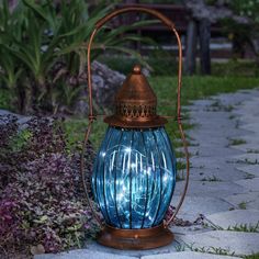 Solar Antique Metal and Sea Blue Glass Accent Lantern with Fifteen LED Firefly String Lights, 7 by 14 Inches | Exhart Solar Yard Art, Solar Garden Lanterns, Solar Powered Lamp, Solar Hanging Lanterns, Yard Sculptures, Backyard Lighting, Metal Garden Art, Solar Lanterns