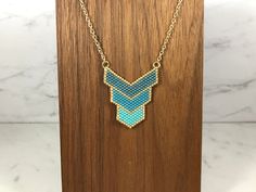 a necklace with blue beads hanging from a wooden stand