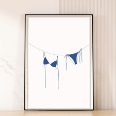 two bikinis hanging on a clothes line against a white wall