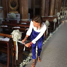 a woman in blue and white is cutting flowers