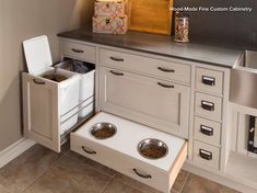 an open drawer in the kitchen with two bowls and one bowl on it's side