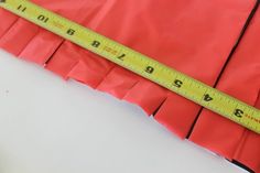 a piece of red paper with a measuring tape on it