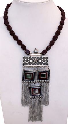 Easy slip on neck wear for a festive and formal look. This is a hand engraved oxidized silver pendant necklace with deep red wine colored beads that define this modern look tribal jewelry. It will add a touch or medieval royal charm to add outfit. Handmade Silver Temple Jewelry Beads, Traditional Brown Beaded Chain, Festive Silver Pendant Beaded Necklaces, Festive Silver Beaded Necklaces With Pendant, Festive Silver Beaded Pendant Necklaces, Festive Bohemian Beads, Traditional Brown Beaded Chain Jewelry, Traditional Red Necklace With Oxidized Finish, Traditional Brown Jewelry For Festive Occasion