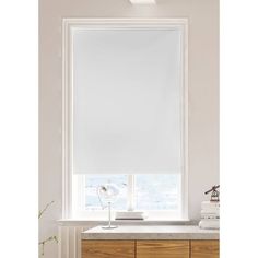 a white roller shade in a bathroom window above a vanity with a sink and mirror