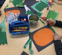 children are making art with construction paper and scissors