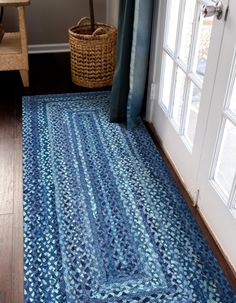 a blue rug on the floor in front of a door with a basket next to it