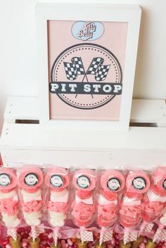 pink and white candies are lined up in front of a framed sign that says pitt stop