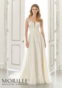 a woman standing in front of an open door wearing a wedding dress with sheer lace