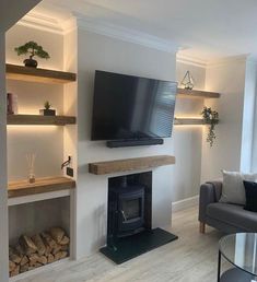 a living room filled with furniture and a flat screen tv mounted on the wall above a fire place