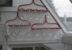 some wine glasses hanging from a rack in a room with a skylight and windows