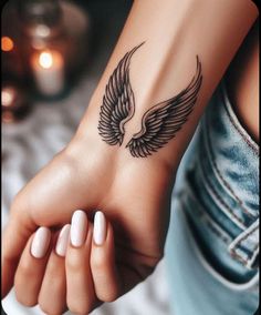 a woman's foot with a tattoo on it and an angel wing above the toe