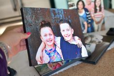 a person holding up an image of two children