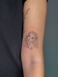 a woman's arm with a tattoo on it and a girl holding a cell phone