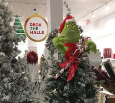 the grinch is sitting on top of the christmas tree in the department's store