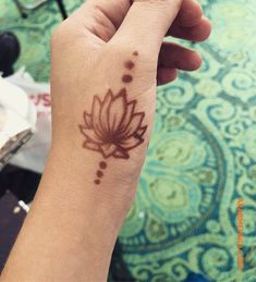 a woman's hand with a tattoo on it that has a flower in the middle