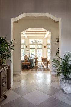 a living room filled with lots of furniture and plants