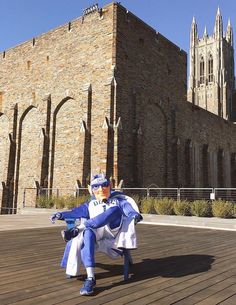 a man dressed in blue and white sitting on a bench