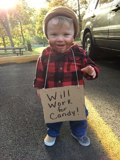 a toddler holding a sign that says will work for candy