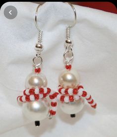 the earrings are decorated with red and white beads