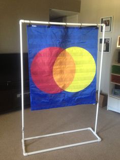 a blue, yellow and red flag hanging on a white stand in a living room