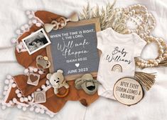 a baby announcement with teddy bears and other personalized items on a white blanket next to it