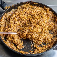 a skillet filled with rice on top of a stove