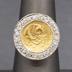 "Chinese 5 Yuan Panda Coin Ring with Diamond Bezel in 14k Yellow Gold This fun piece is full of luck and luxe!  The ring features a 5 yuan Panda coin, 1/20oz of .999 gold.  The coin is bezel set and surrounded by a frame of round prong set diamonds.  The diamonds measure 1.5 to 2.0mm, there are 21 of them leading to a calculated total weight of approximately 0.30cttw.  The diamonds are H/I color and average I1 clarity with no eye visible inclusions.  The coin stands a bit off of the finger with