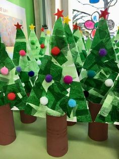 paper christmas trees made out of construction paper with pom - poms on them