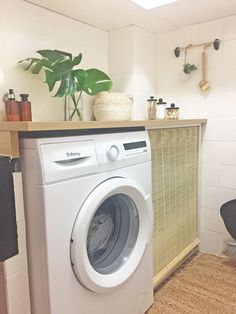 a washer and dryer sitting in a room next to a counter with potted plants on it