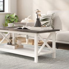 a white coffee table with books on it in a living room next to a couch