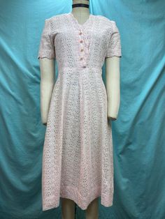 1940s W:27 vintage 40s pink embroidery eyelet cottton shirt dress pearl shank buttons short sleeve  Beautiful 40s vintage dress. Made out of light weight cotton with eyelets and roses embroidery in light powder pink color. Classic shirt dress with scalloped edge V neckline and short sleeves. Hiked natural waist and A-line skirt. Dress with side zipper and non functional pearl shank buttons. Unlined. Photographed on fit form size 2. MEASUREMENTS  Bust: 36" Waist: 27" Hips: 44" Shoulder to waist: 1940s Pink Dress, Feminine Eyelet Dress With Short Sleeves, Feminine Vintage Short Sleeve Wedding Dress, 1950s Style Short Sleeve Summer Dress, Pink Short Sleeve Dress With Buttons, Feminine Fitted Vintage Dress With Short Sleeves, Short Sleeve Eyelet Dress For Daywear, Pink Short Sleeve Dress With Button Closure, White Vintage 1950s Style Dress With Short Sleeves