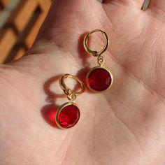 These earrings feature 10mm siam ruby red vintage stones attached to gold plated 11mm hoops. Red Gold Plated Drop Earrings, Red Brass Drop Earrings, Nickel-free Red Round Earrings, Nickel Free Red Earrings, Gold Ruby Round Earrings, Red Faceted Dangle Earrings, Gold Faceted Ruby Earrings, Red Ruby Hoop Earrings, Elegant Small Hoop Red Earrings