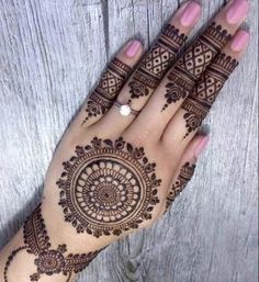 a woman's hand with henna tattoos on it