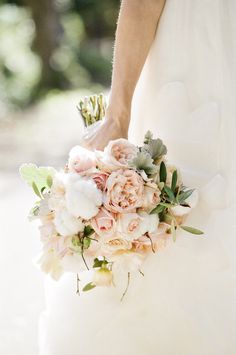 a bride holding a bouquet of flowers in her hand