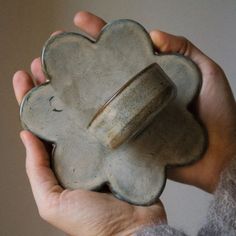 a person holding a clay object in their hands