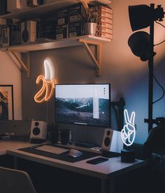 a computer desk with two monitors on top of it in front of a bookshelf