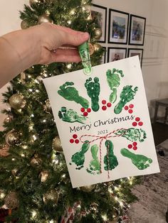 a handprinted christmas ornament hanging from a tree