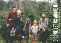 a group of people standing next to each other in front of a christmas tree farm