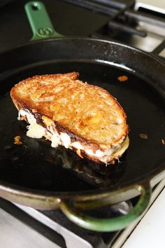 a grilled cheese sandwich is being cooked in a skillet on the stove top