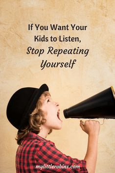 a young boy wearing a cowboy hat and holding a black megaphone to his ear