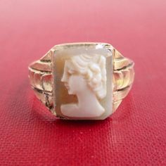 A vintage ring with hand carved shell cameo face (I added the cameo to the face since I'm guessing it originally had something there).  A size 5 1/2 on my ring sizer.  Marked "1/20 10K G.F." with a hallmark.  Front is 11mm tall (up and down in the 1st photo).  The ring shows vintage surface wear / scratches and darkness.   Please check out my store with similar things added almost daily. Remember, shipping for additional items is always free. Vintage Cameo Signet Ring, Vintage Cameo Rings For Collectors, Vintage Cameo Signet Ring For Anniversary, Vintage Carved Signet Ring Collectible, Vintage Carved Signet Ring, Antique Cameo Signet Ring Collectible, Vintage Carved Wedding Signet Ring, Cameo Ring, Carved Shell