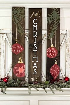 three wooden christmas ornaments hanging on a mantel