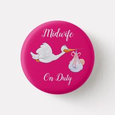 a pink button with a stork delivering a baby on it's back