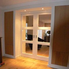 an empty room with wooden floors and sliding glass doors that lead into the living area