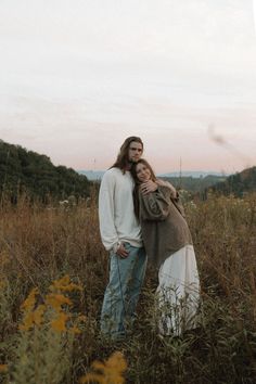 two people standing in tall grass near each other