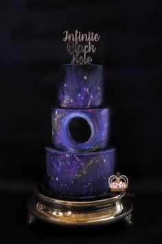 a three tiered cake with purple and blue icing