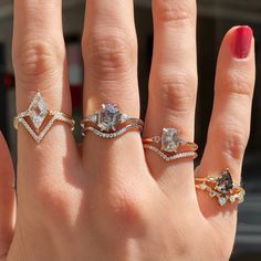 a woman's hand with three different rings on it and one is wearing a diamond ring